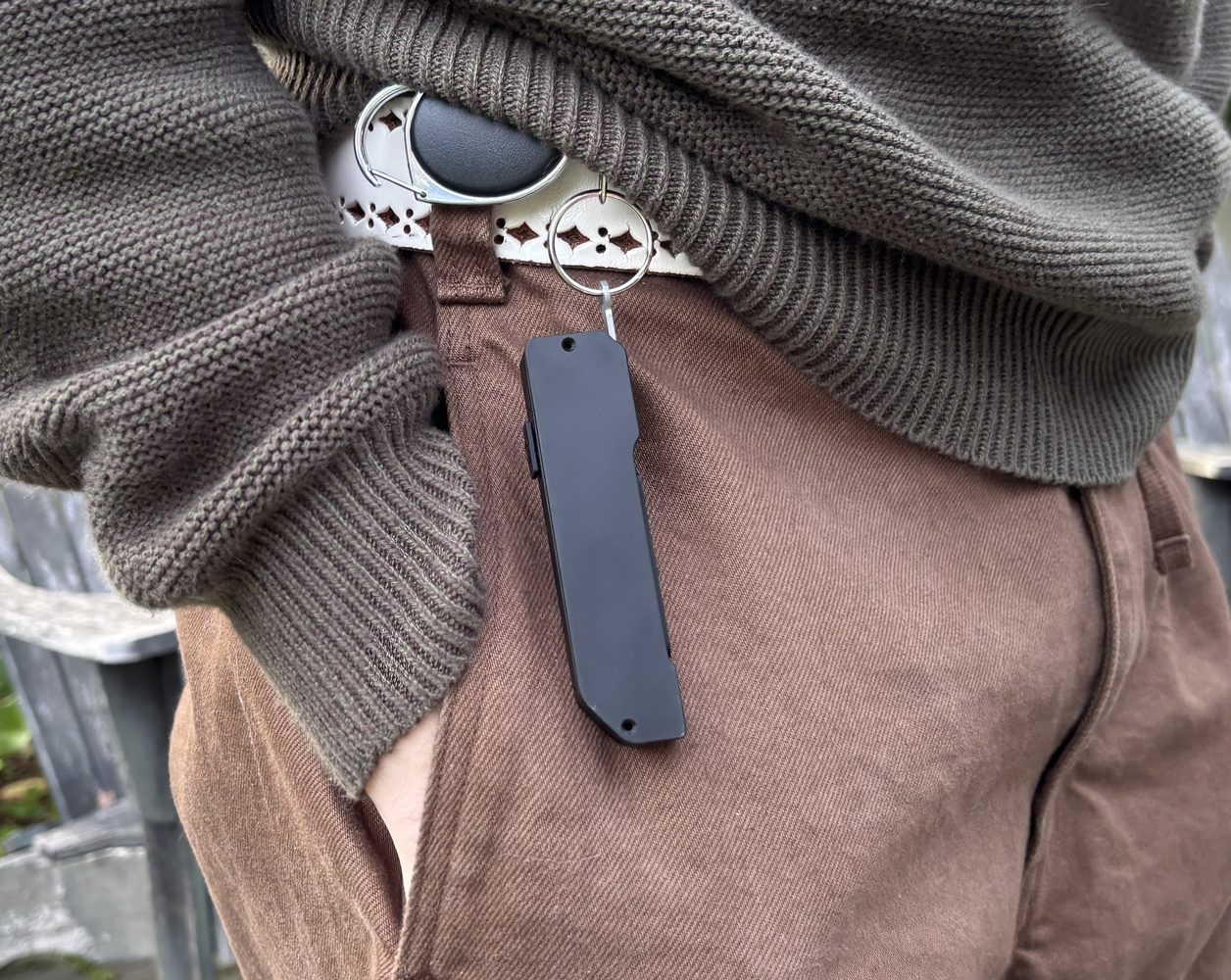 Glance clipped to a belt beside a trouser pocket